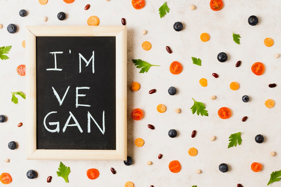 tabliczka z napisem i'm vegan, dookoła warzywa